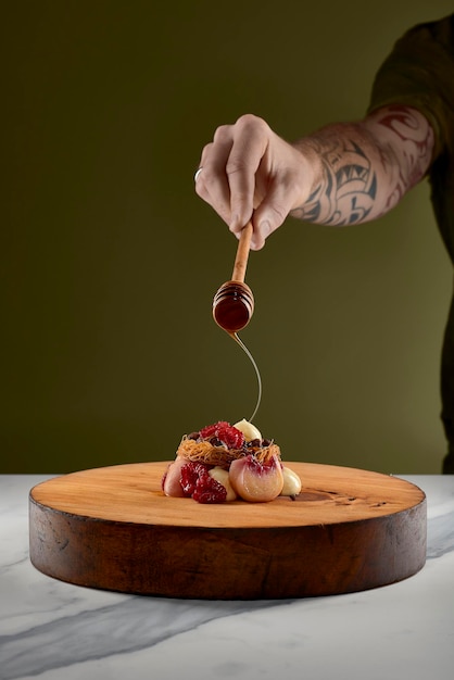 Manos de chef decorando plato